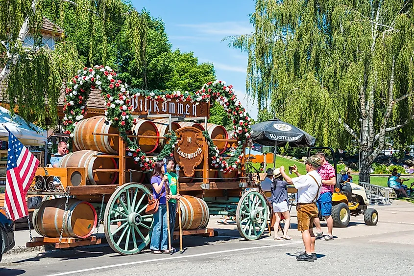 Tourists have a souvenir photo taken in front of a beer wagon float in Leavenworth, Washington