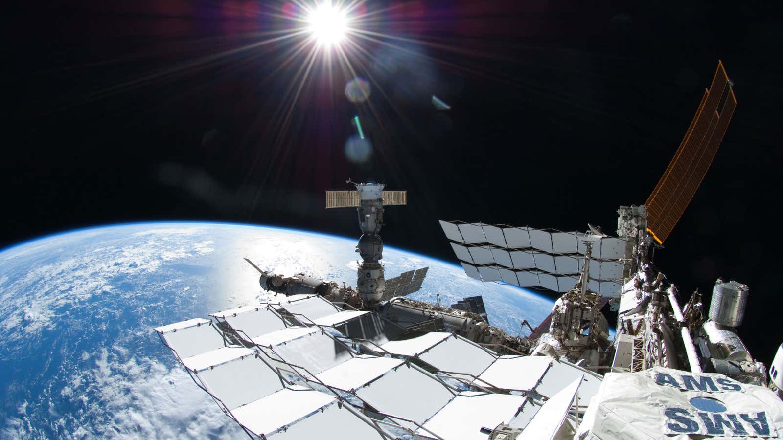 Exterior view of the International Space Station (ISS) taken during a session of Extravehicular Activity (EVA) with a fisheye camera. The Alpha Magnetic Spectrometer - 2 (AMS-2) is visible in the right foreground and a Soyuz spacecraft is visible docked to the Pirs Docking Compartment (DC1/CO1). The Alpha Magnetic Spectrometer - 02 (AMS-02) is a high profile space-based particle physics experiment. As the largest and most advanced magnetic spectrometer in space, AMS-02 will collect information from cosmic sources emanating from stars and galaxies millions of light years beyond the Milky Way.