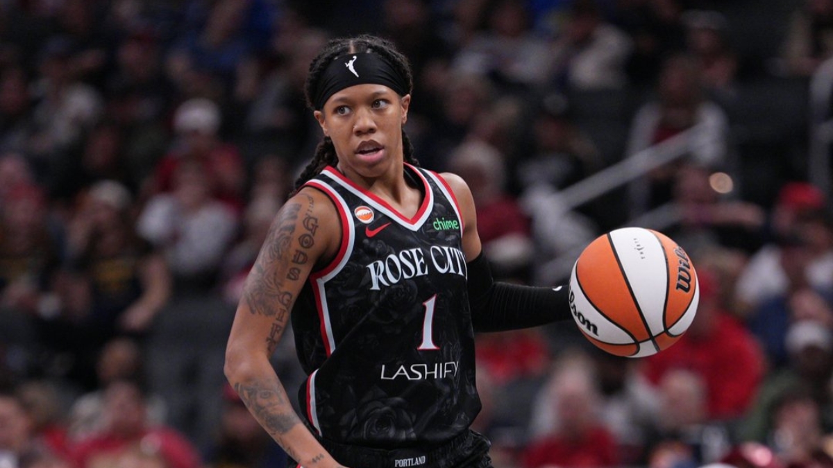 Sug Sutton dribbles up the court in a Portland Fire jersey during a game against the Indiana Fever