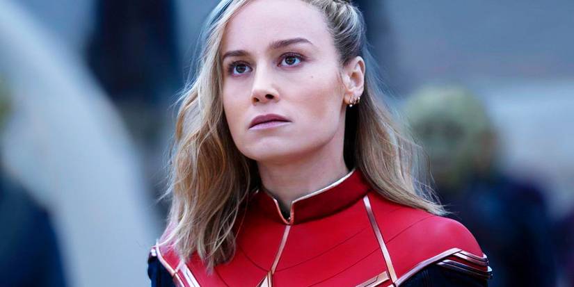 Brie Larson as Carol Danvers looking at an object offscreen in The Marvels.