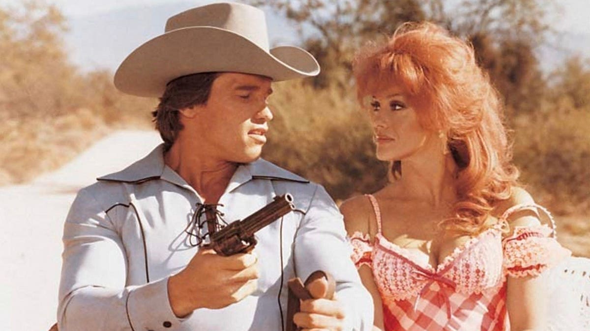 Arnold Schwarzenegger and Ann-Margret posing for a promotional photo for The Villain film.