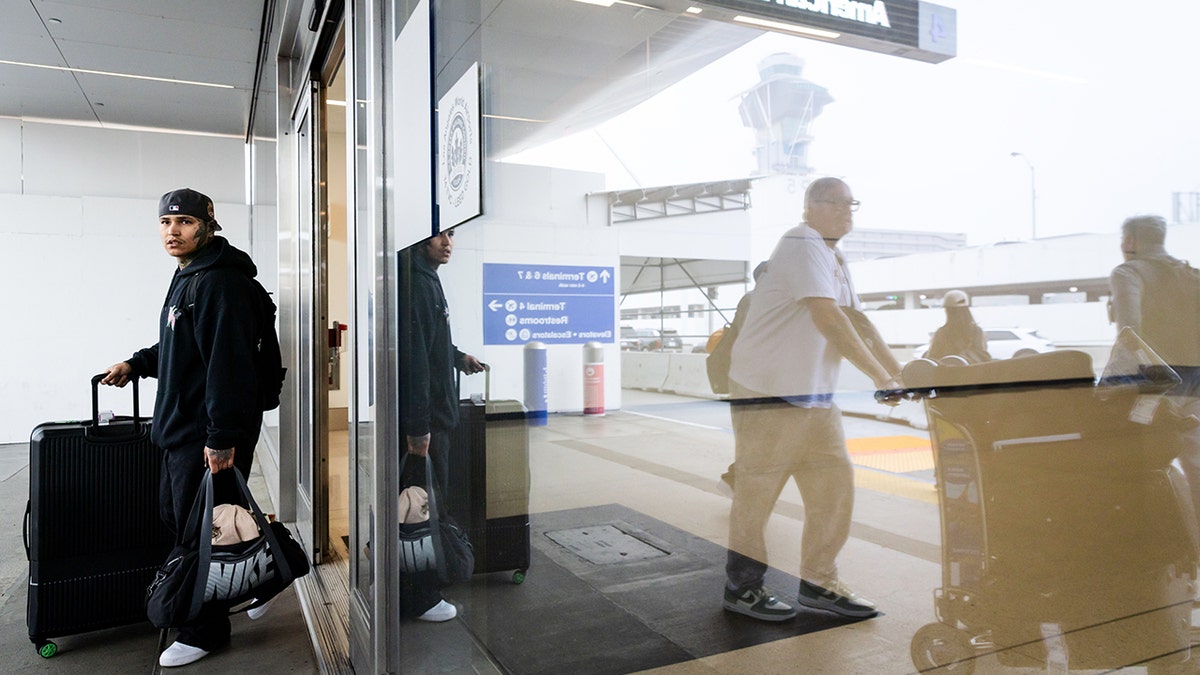 Travelers exiting a terminal at Los Angeles International Airport