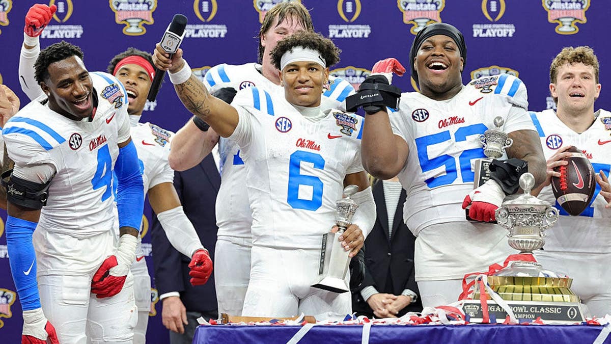 Trinidad Chambliss celebrating on stage with Ole Miss teammates