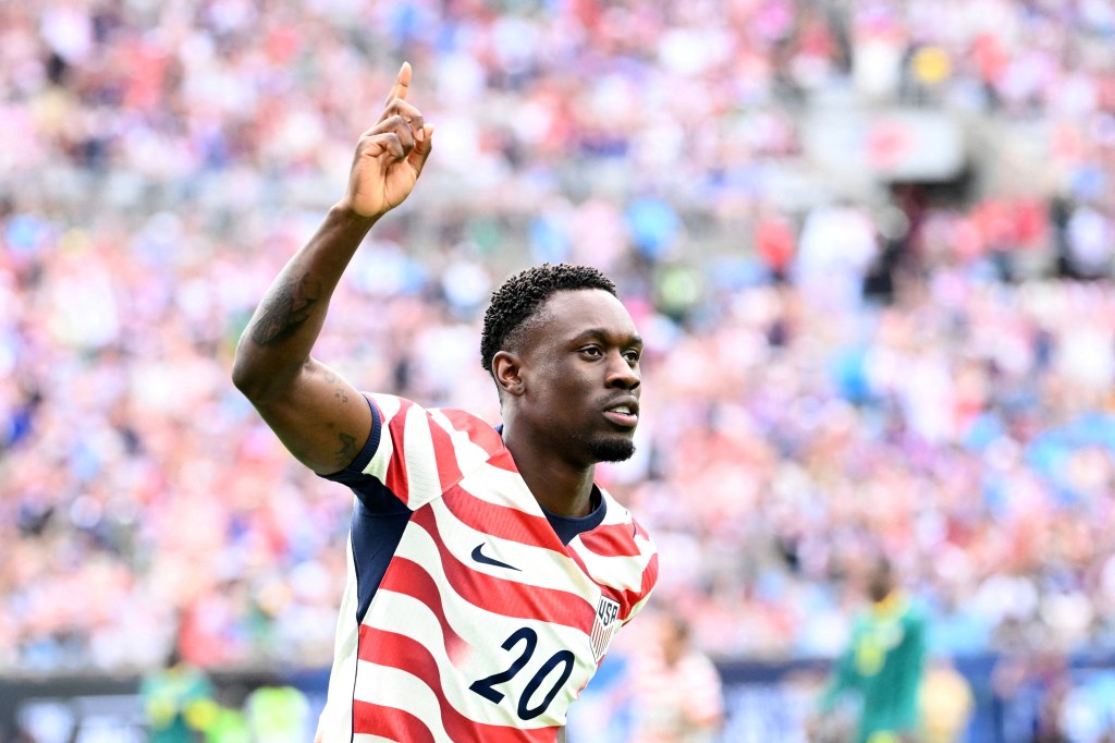United States forward Folarin Balogun raises his arm and points his finger.