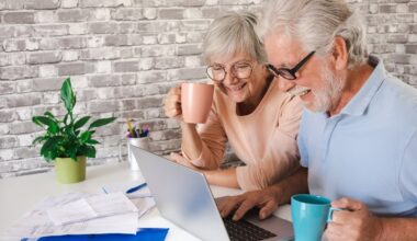 Two smiling people at a laptop.