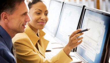 An investor points something out to another investor on a computer screen.