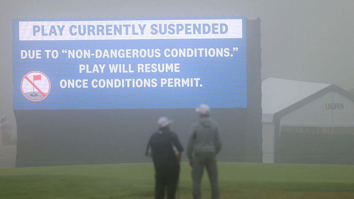 A video board displaying a message about play suspension at Shinnecock Hills Golf Club.