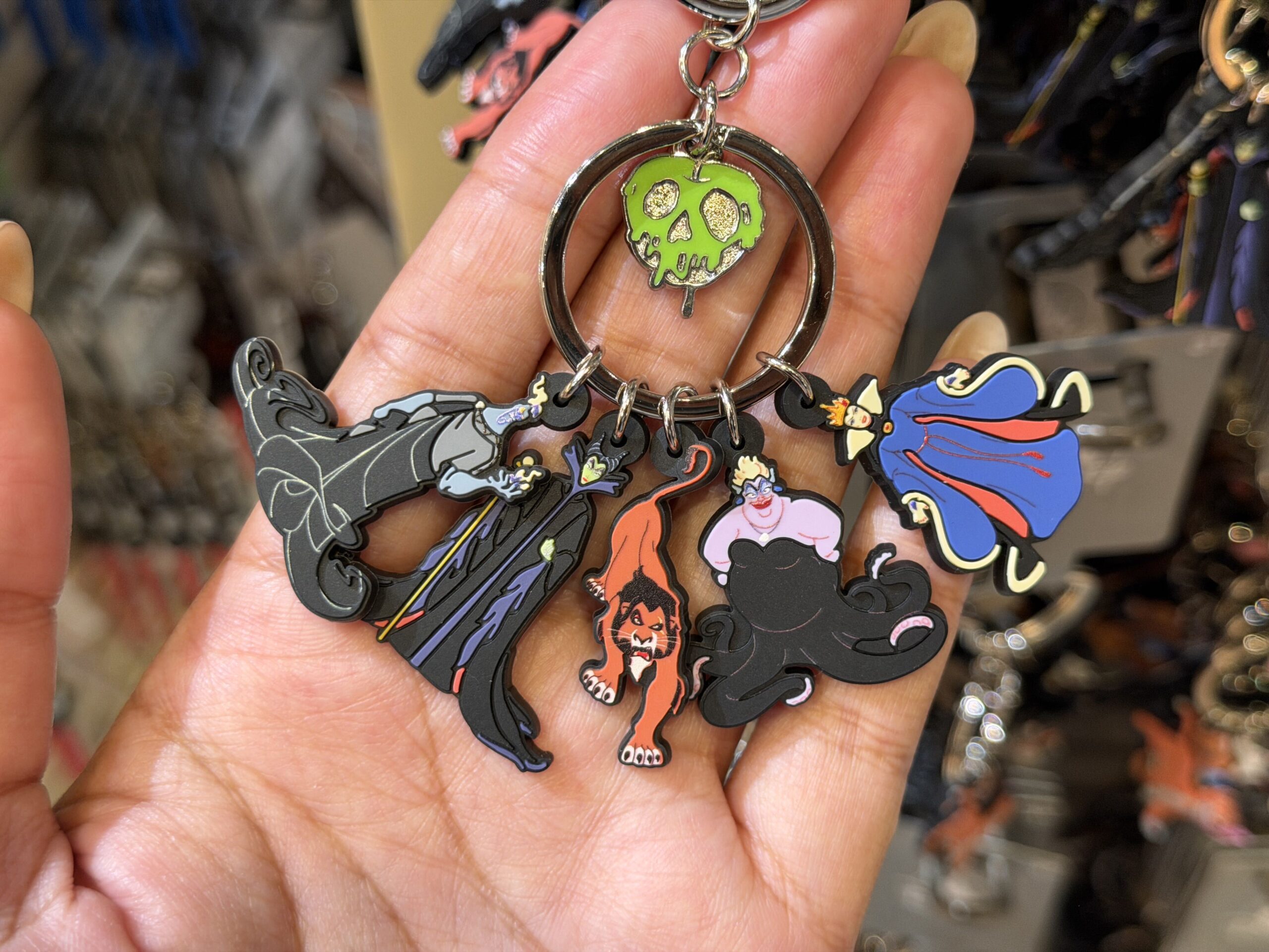 Unlike the other keychain sets, this one showcases villainous characters from five different films. These characters are Hades, Maleficent, Scar, Ursula, and The Evil Queen. The Evil Queen's poison apple hangs in the center ring.