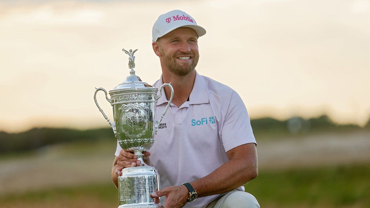 Wyndham Clark posing with the U.S. Open Championship Trophy at Shinnecock Hills Golf Club