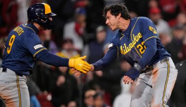 Milwaukee Brewers' Christian Yelich, right, is congratulated by Jake Bauers (9) after scoring on a single by Garrett Mitchell during the eighth inning of a baseball game against the Boston Red Sox at Fenway Park, Monday, April 6, 2026, in Boston. (AP Photo/Charles Krupa)