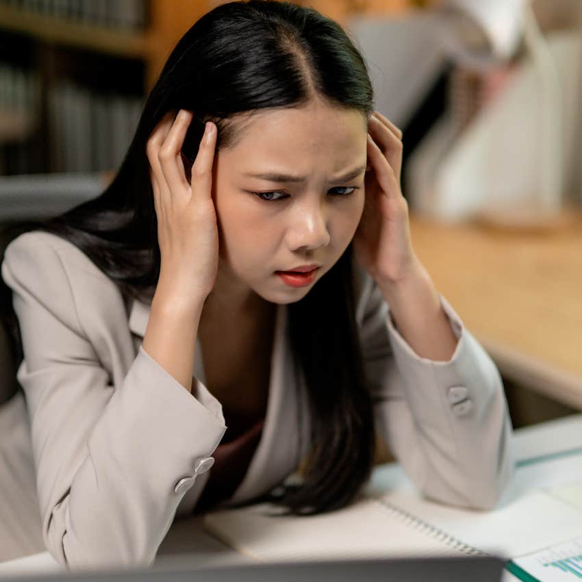 miserable woman proving her worth at work but looking stressed
