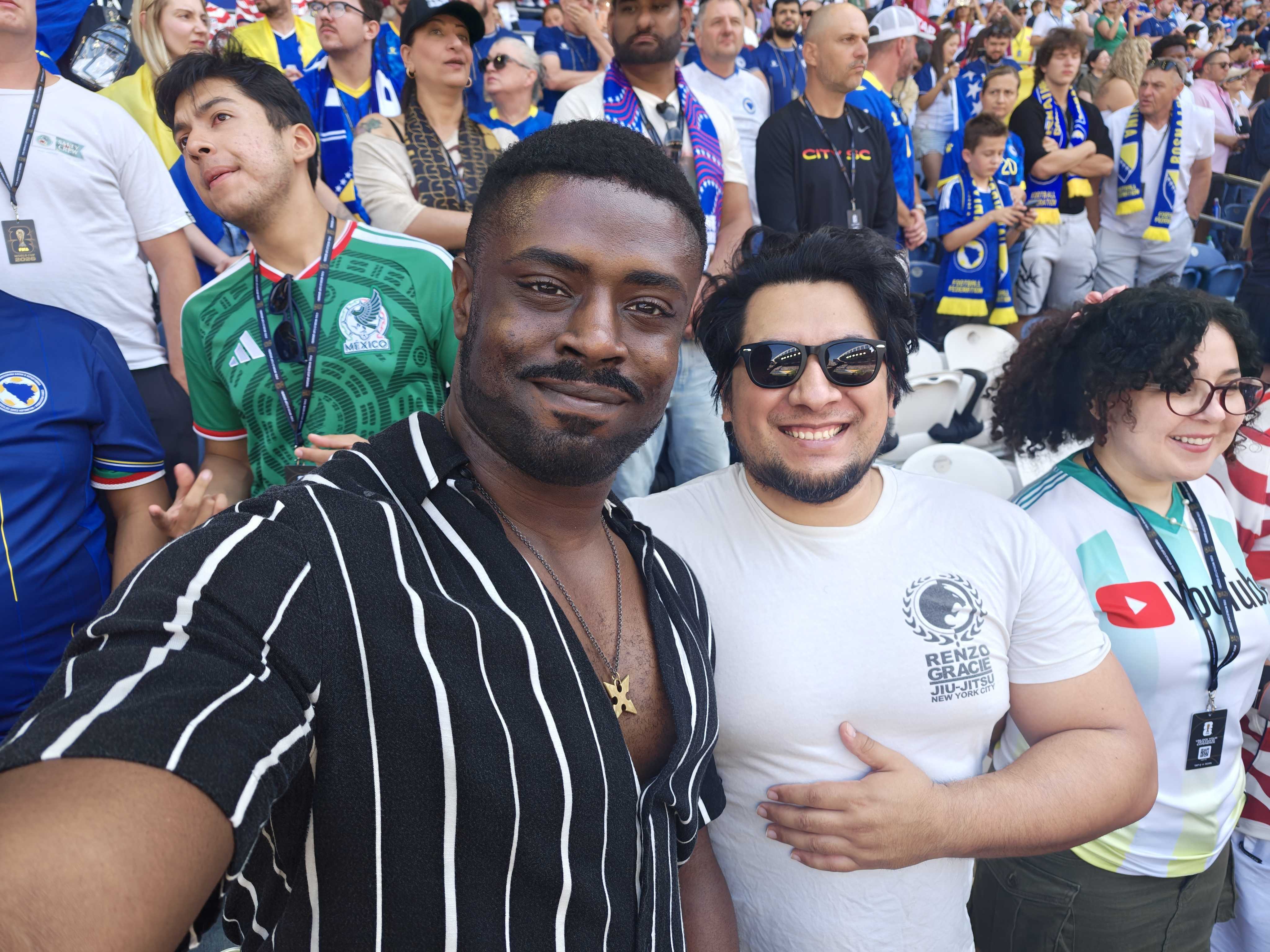 Two men smiling next to each other in the stands