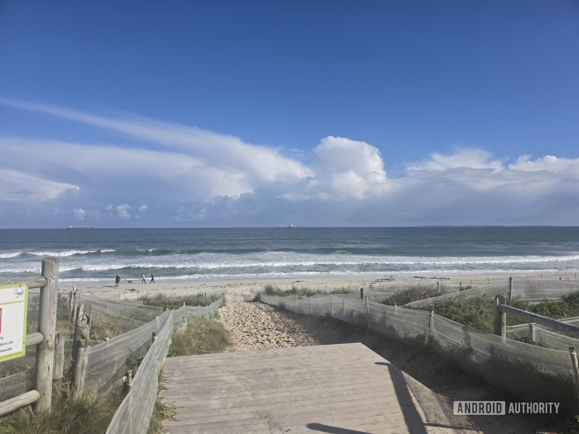 zoomed out photo of beach with boat in distance