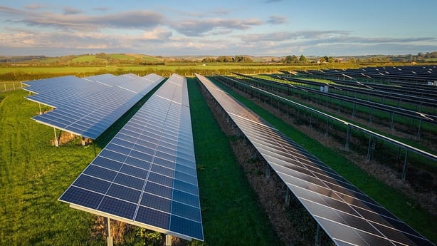 The sun shines on solar panels at a solar farm