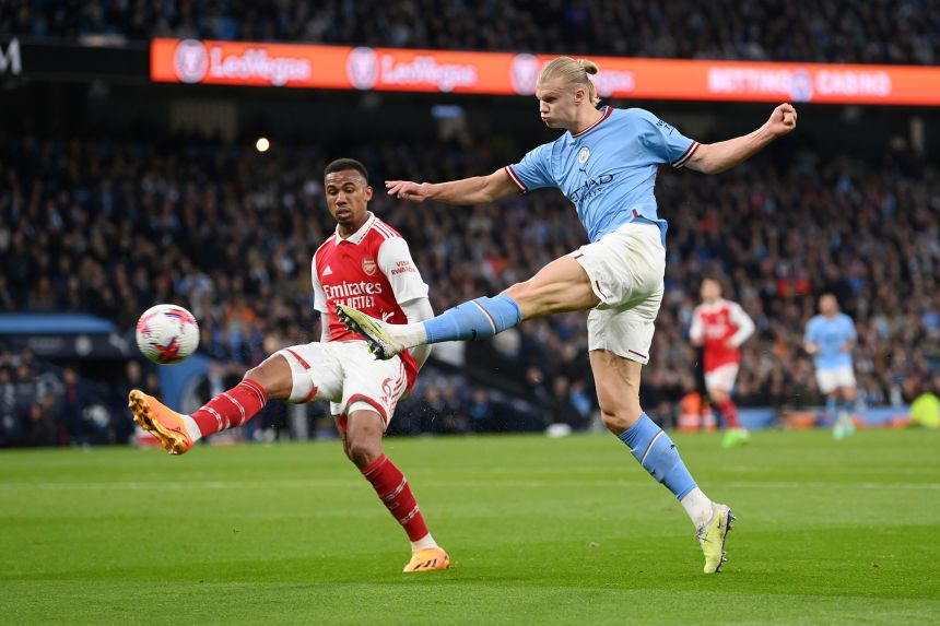 Erling Haaland of Manchester City shoots past Gabriel of Arsenal during a match in April 2023.