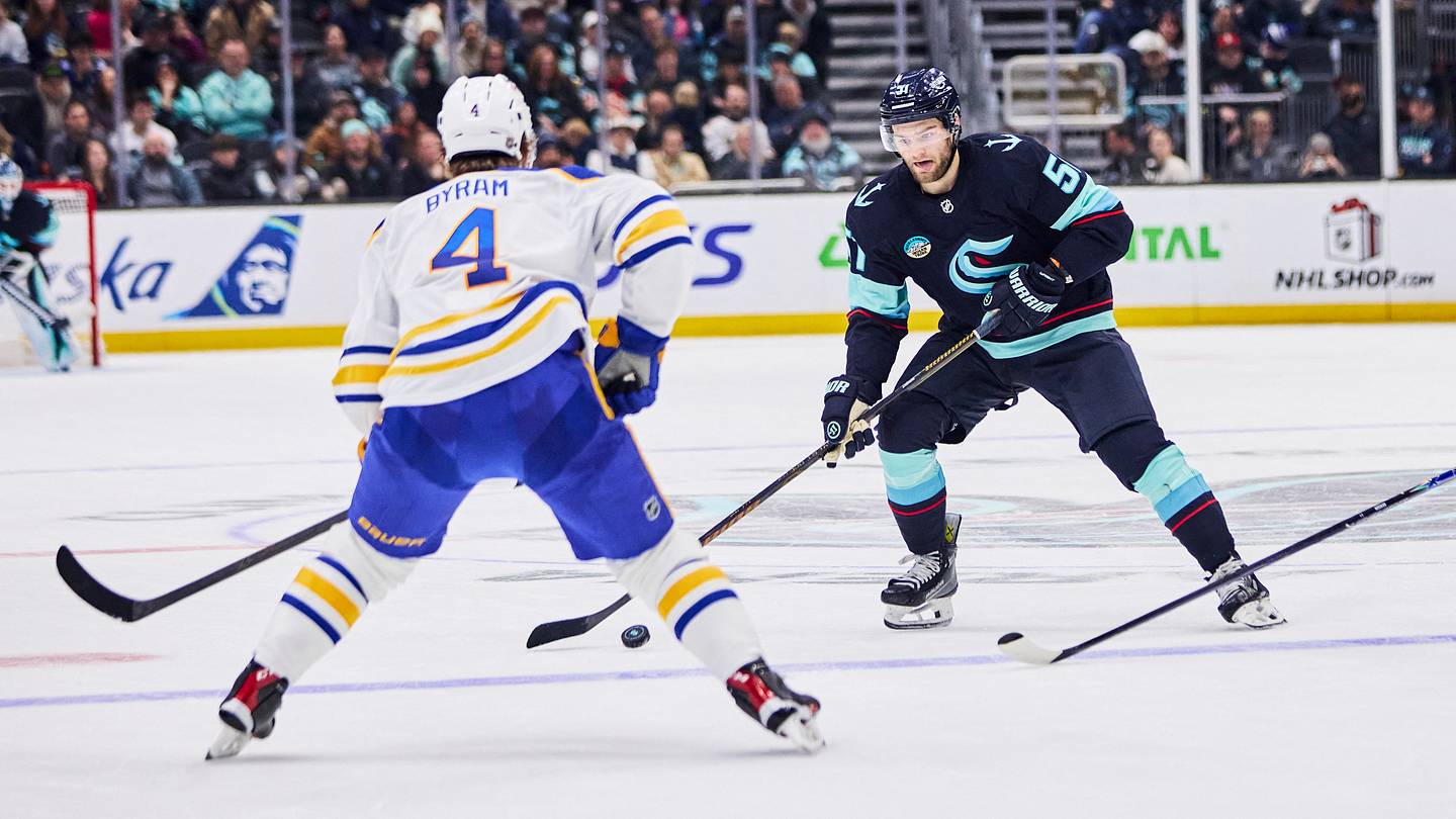 Dec 14, 2025; Seattle, Washington, USA; Seattle Kraken center Shane Wright (51) looks to pass as Buffalo Sabres defenseman Bowen Byram (4) defends during the second period at Climate Pledge Arena. Mandatory Credit: Blake Dahlin-Imagn Images