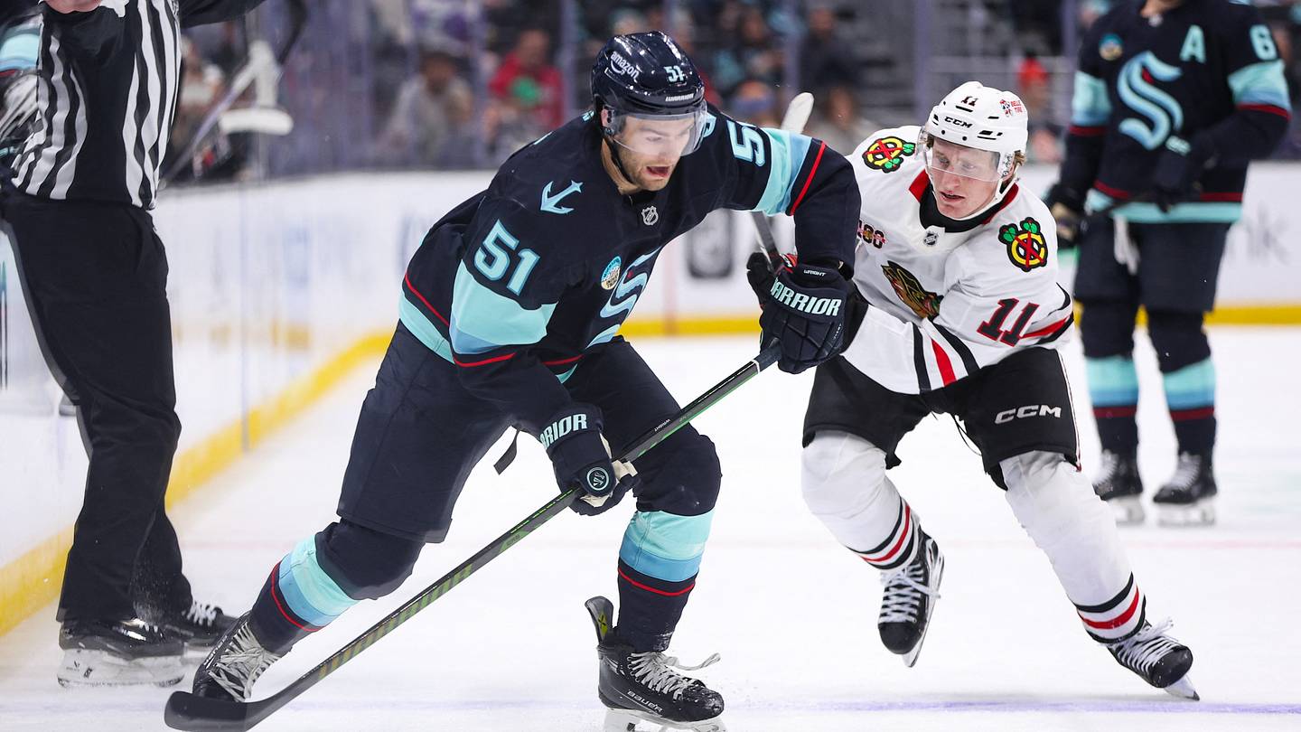 Nov 3, 2025; Seattle, Washington, USA; Seattle Kraken center Shane Wright (51) looks to pass past Chicago Blackhawks center Oliver Moore (11) in the second period™ at Climate Pledge Arena. Mandatory Credit: Kevin Ng-Imagn Images