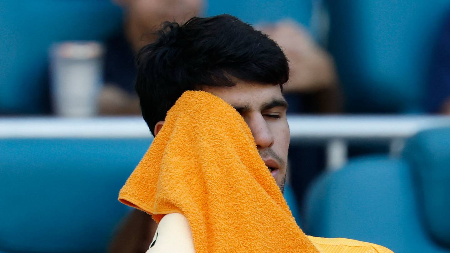 Carlos Alcaraz wipes his face in his player's chair