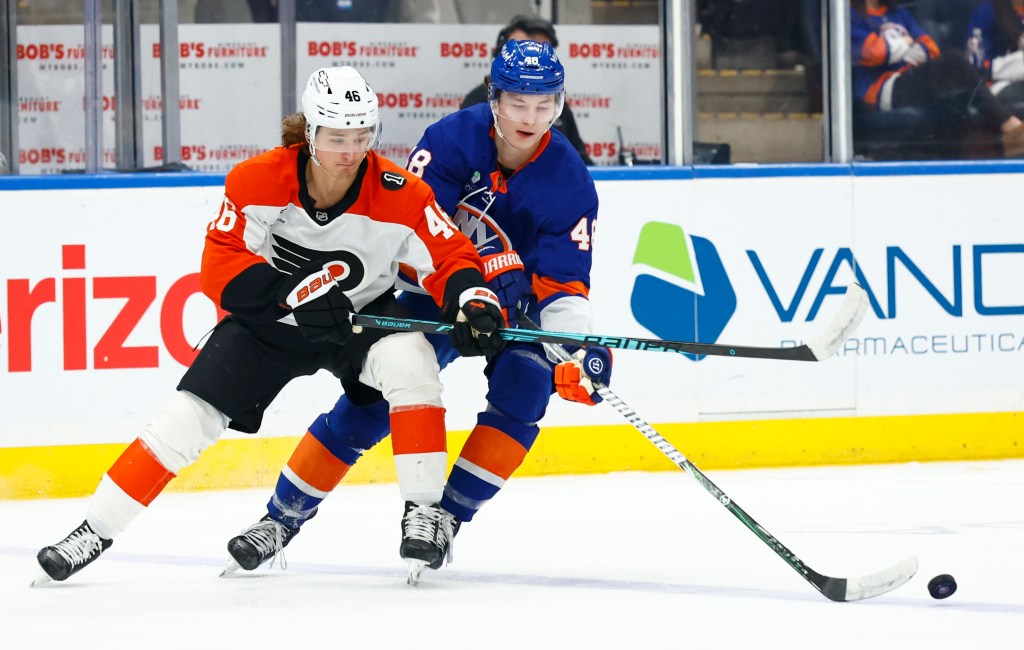 Philadelphia Flyers center Trevor Zegras (46) and New York Islanders defenseman Matthew Schaefer (48) battle for the puck.