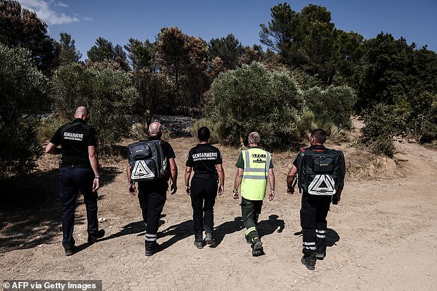 Members of the Recherche des Causes et Circonstances d'Incendie - RCCI of the Var department (Fire Causes and Circumstances Investigation) unit are pictured at the site of a suspected reignition point of a wildfire in Ponteves