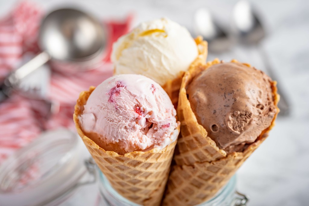 Three ice cream cones, one with strawberry, one with vanilla, and one with chocolate ice cream.