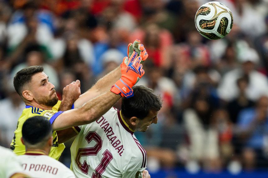 Spanish goalkeeper Unai Simón punches the ball clear against France.