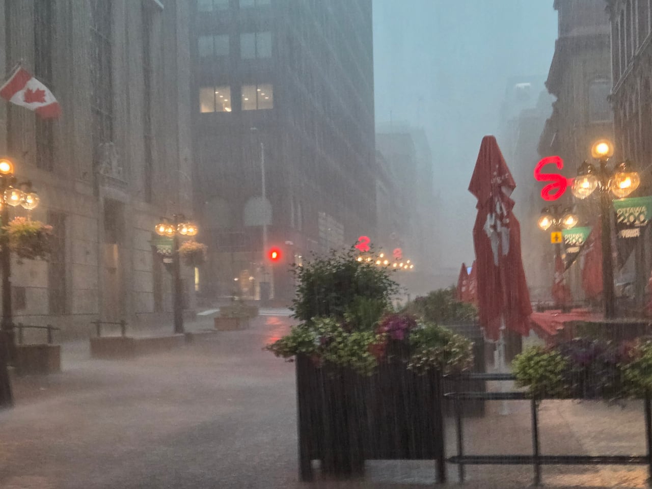 A pedestrian street covered so heavily with rain you can't see down it.