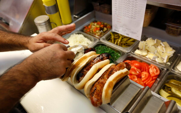 Kitchen staff prepare gourmet entrée at Doug Sohn's Hot Doug's restaurant on the northwest side of Chicago on Oct. 9, 2013. (AP Photo/M. Spencer Green, File)