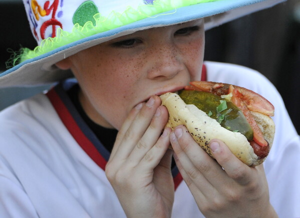A young fan eats a hot dog before a baseball game between the Chicago White Sox and the Houston Astros, in Chicago on June 9, 2015. (AP Photo/David Banks, File)