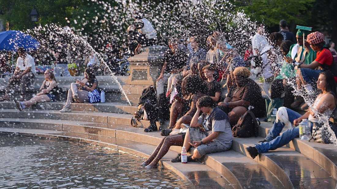 People spend time at Washington Square Park during hot weather in New York City on Monday.
