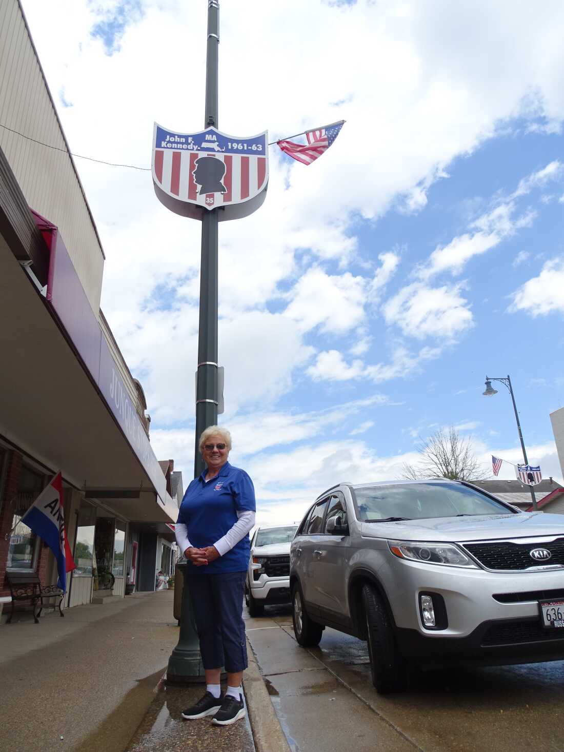 Donna Rogers shows off one of Cuba City's presidential lampposts.