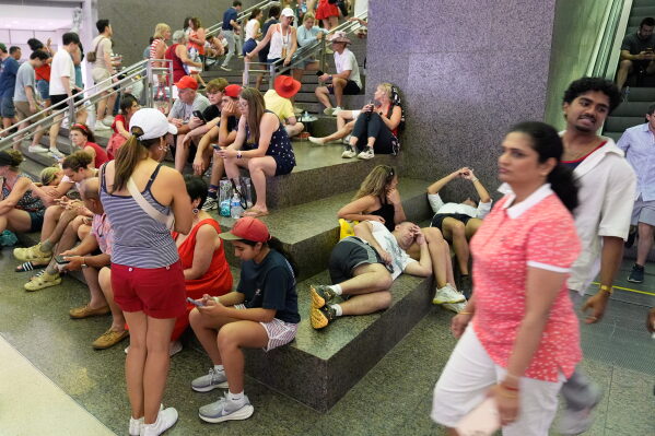 People take cover in the Ronald Reagan Federal Building after evacuating the National Mall due to weather while attending Independence Day events honoring the nation's 250th anniversary, Saturday, July 4, 2026, in Washington. (AP Photo/Pablo Martinez Monsivais)