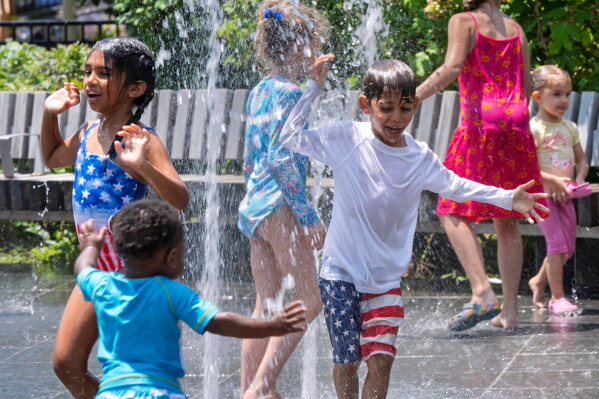 Children cool off from the hundred-degree heat at a spray park on Capitol Hill in Washington, Saturday, July 4, 2026. (AP Photo/J. Scott Applewhite)