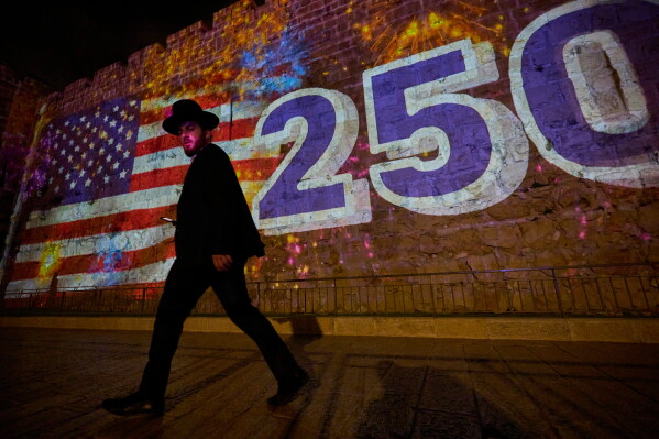 An ultra-Orthodox Jewish man walks past a projection of the American flag on the walls of Jerusalem's Old City, Sunday, July 5, 2026, displayed in honor of the 250th anniversary of U.S. independence. (AP Photo/Ohad Zwigenberg)
