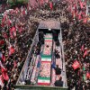 Flower petals are thrown on the coffins of Iran's slain Supreme Leader Ali Khamenei and his family members along a street during their funeral procession in Tehran on Monday.