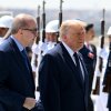 Turkish President Recep Tayyip Erdogan and President Trump walk side by side upon Trump's arrival at Etimesgut Air Base in Turkey on July 7. Rows of people wearing military-style uniforms and holding rifles stand behind the two men.