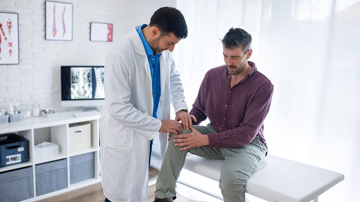An orthopedist checks a patient's knee.