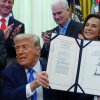 President Trump holds up a bill funding immigration enforcement after signing it in the Oval Office of the White House, Wednesday, June 10, 2026, in Washington.