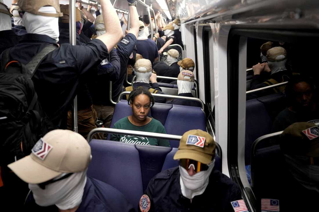 Members of the group Patriot Front ride the subway as a commuter looks on, in Washington, D.C., on July 4.