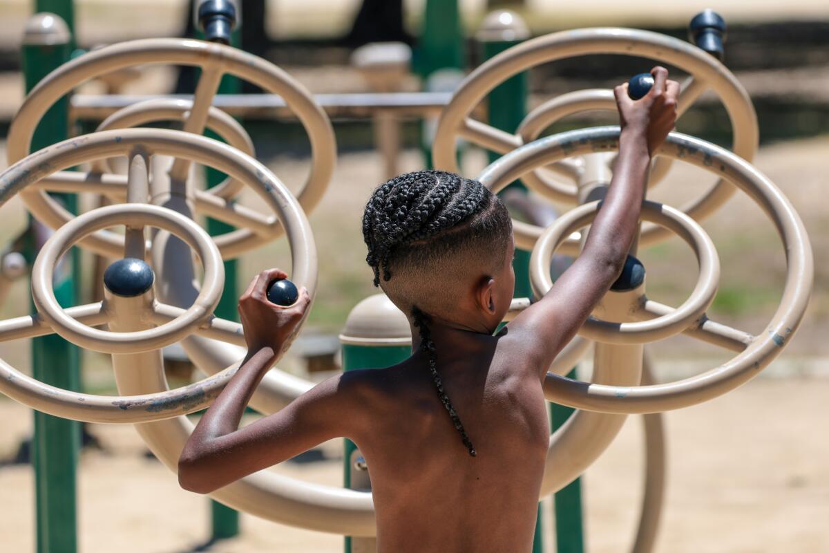 Mateo Johnson, 8, of North Hollywood works out his arms as temperatures reach the low 90's at North Hollywood Park 
