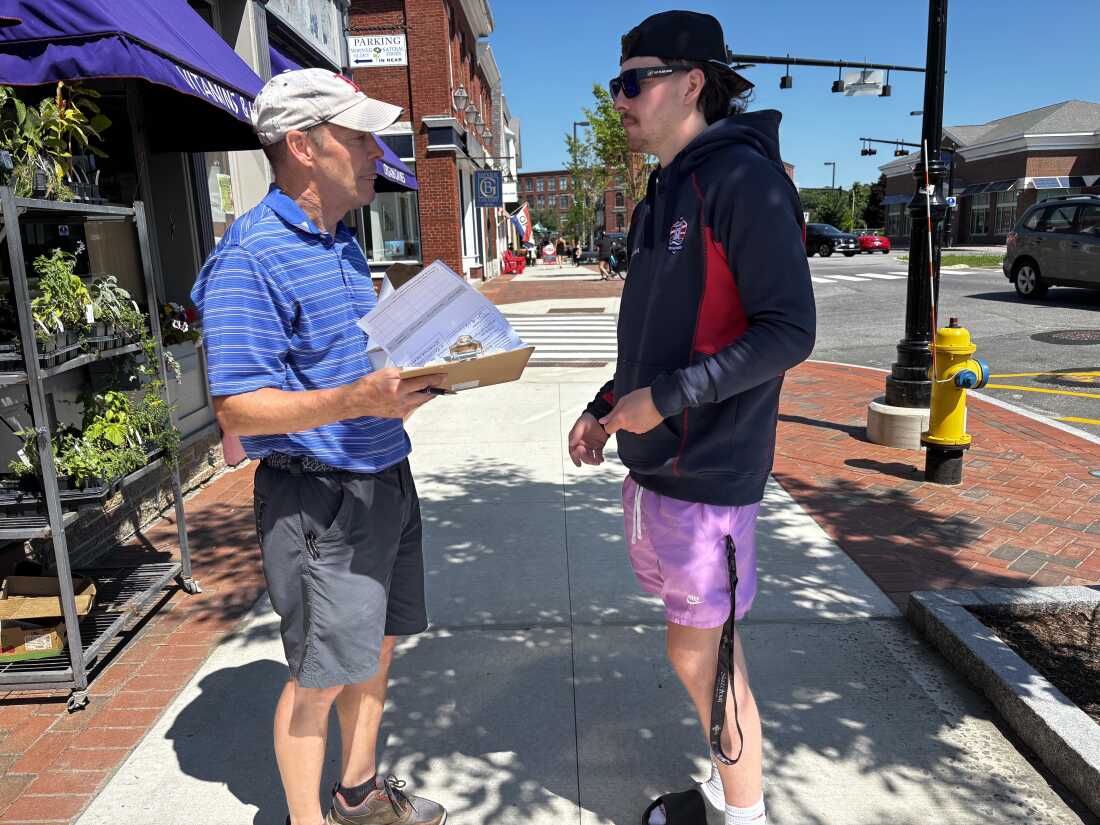 Maine Senate hopeful, Democrat David Costello, speaks with a potential voter as he gathers signatures, required to be considered at the party's convention in downtown Brunswick, Maine on July 12.