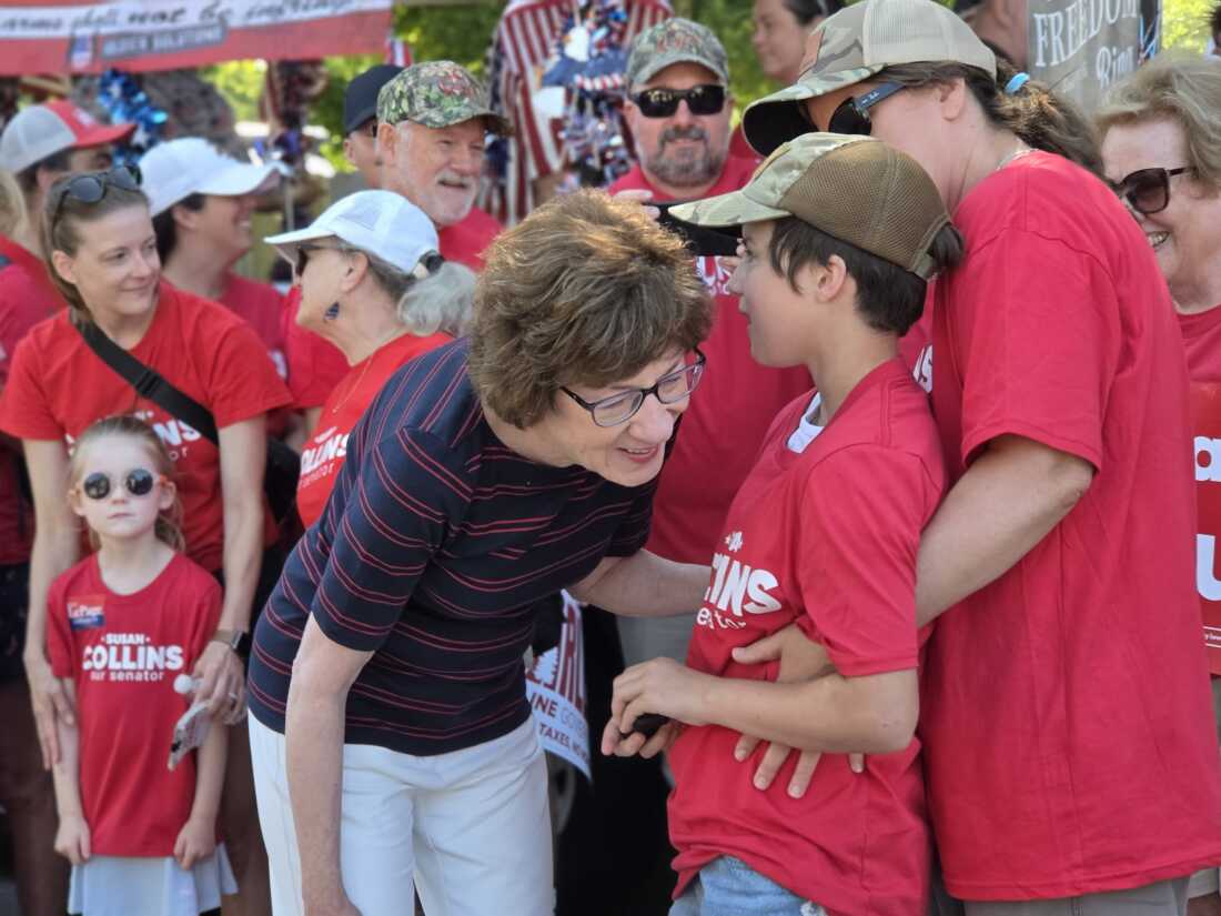 Sen. Susan Collins, R-Maine, leans down to listen to a young paradegoer at the annual Moxie Day Parade is Lisbon, Maine on July 11.