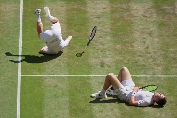 Harri Heliovaara of Finland, left and playing partner Henry Patten of Britain react after defeating Marcelo Arevalo of El Salvador, and Mate Pavic of Croatia, in the men's doubles final at Wimbledon Tennis Championships in London, Saturday, July 11, 2026. (AP Photo/Brian Inganga) CORRECTION: Corrects the second name of Henry and the nationality of Marcelo Arevalo.