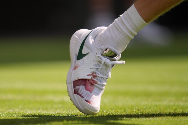 Italy's Jannik Sinner's right shoe shows a red stain during the men's singles match against Miomir Kecmanovic of Serbia at the Wimbledon Tennis Championships in London, Monday, June 29, 2026.(AP Photo/Kin Cheung)