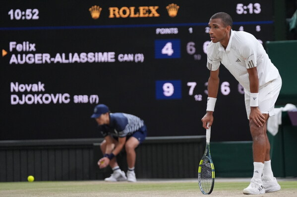 Felix Auger-Aliassime of Canada reacts after losing a point against Novak Djokovic of Serbia, as the match clock reaches five hours and 13 minutes, making it the longest Wimbledon men's singles quarterfinal in history, at the Wimbledon Tennis Championships in London, Tuesday, July 7, 2026. (AP Photo/Maja Smiejkowska)