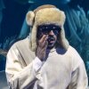 Singer and rapper Bad Bunny standing on stage with supporting musicians.