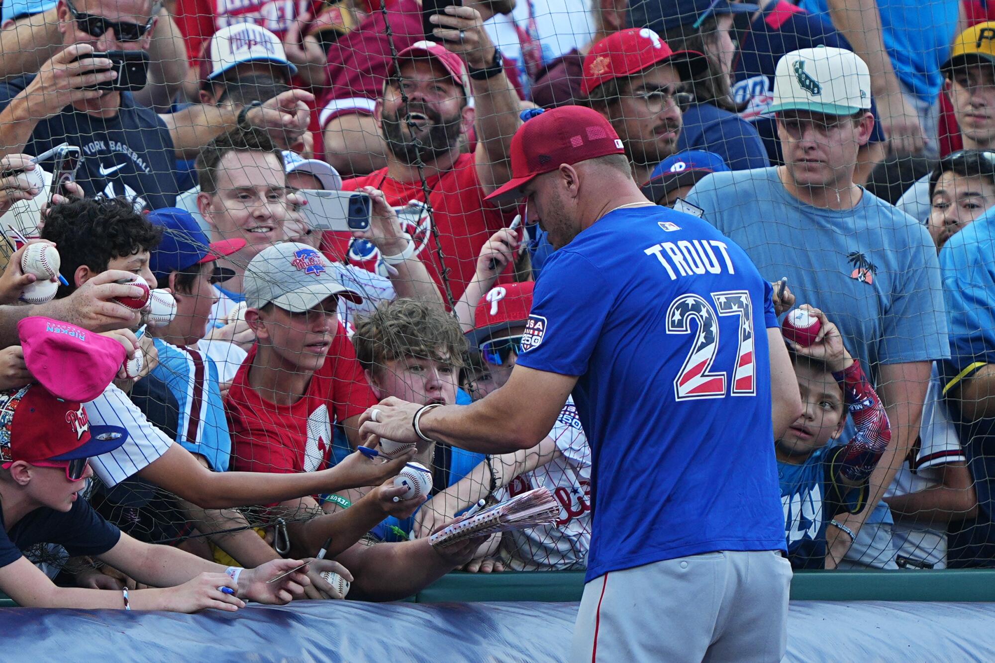 Mike Trout signs autographs before the home run derby Monday.