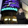 In this photo from 2000, a woman holding a cellphone to her ear walks past the illuminated Nasdaq sign in New York City's Times Square.