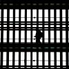 In this file photo, a man using a smartphone passes through the arched windows at Grand Central Terminal in New York City on March 24, 2025.