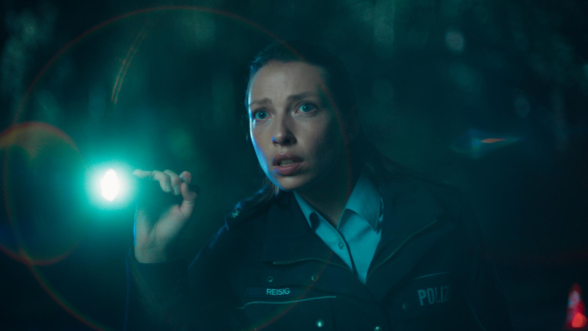 A police officer hold a flashlight in "Dear Child."